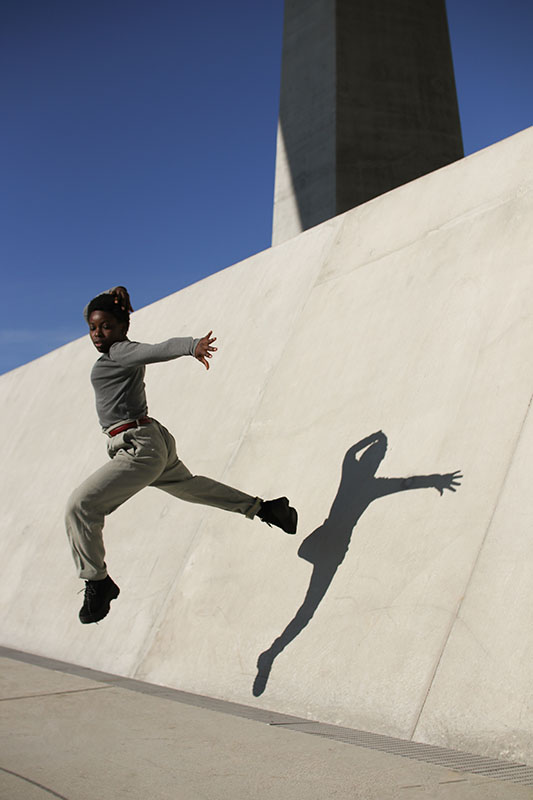 Danseuse et son ombre portée sur mur en béton