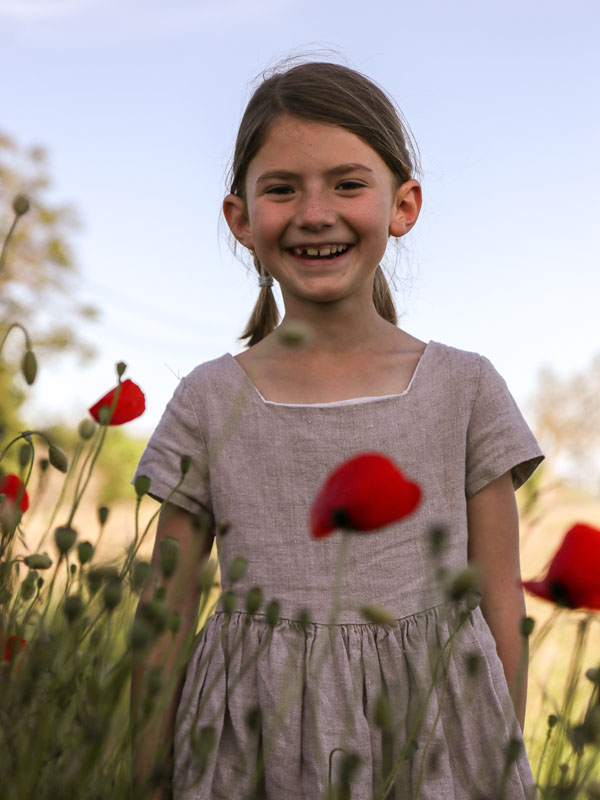Fillette souriante dans un champ de blé