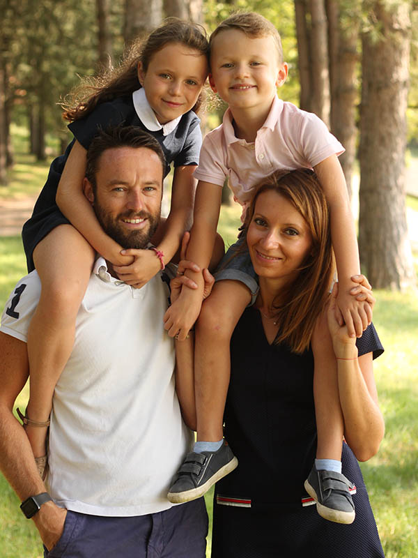 Famille dans un parc avec enfants sur les épaules