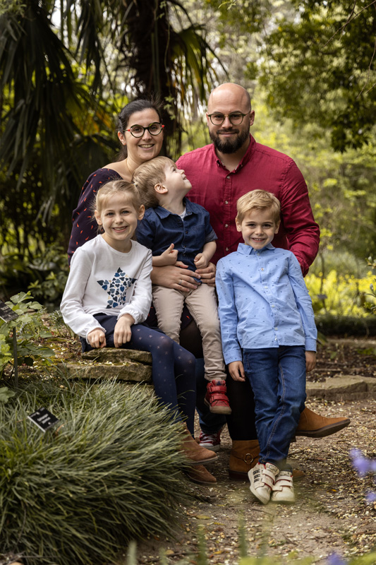Parents avec leurs 3 enfants dans un coin ombragé du parc de la tête d'or