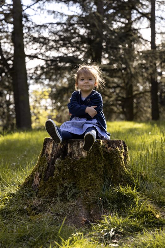 Portrait d'une filette assise sur une souche