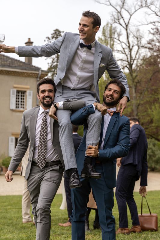 Marié porté par ses témoins dans le parc du domaine